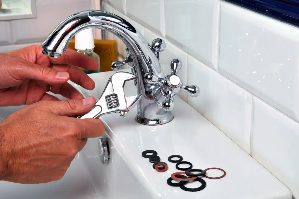 Plumber performing maintenance on a bathroom faucet in Murray