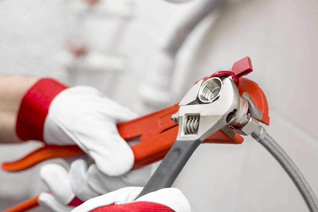 Plumber holding pipe wrenches for an emergency repair in Murray