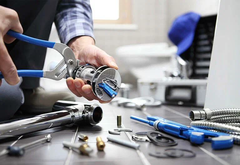 Technician repairing a plumbing fixture with professional tools in Murray