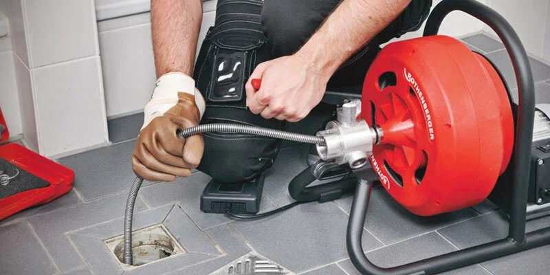 Plumber using a drain-cleaning machine in Murray