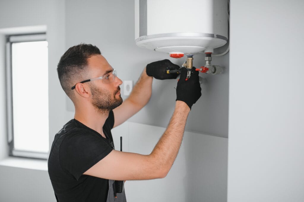 Technician performing water heater maintenance in Murray