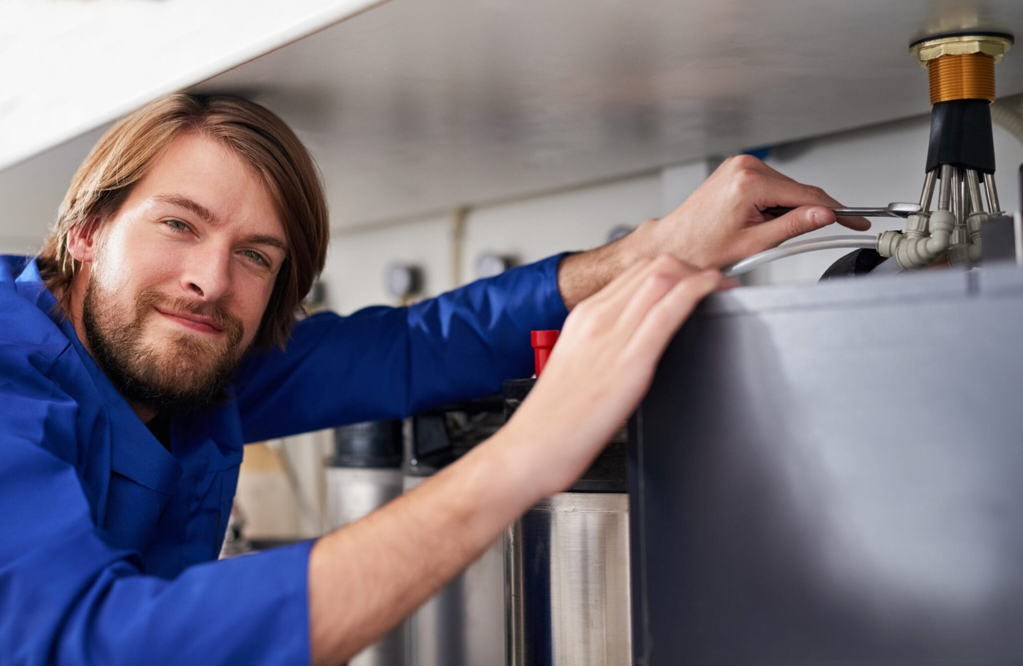 Technician servicing a residential water heater tank in Murray